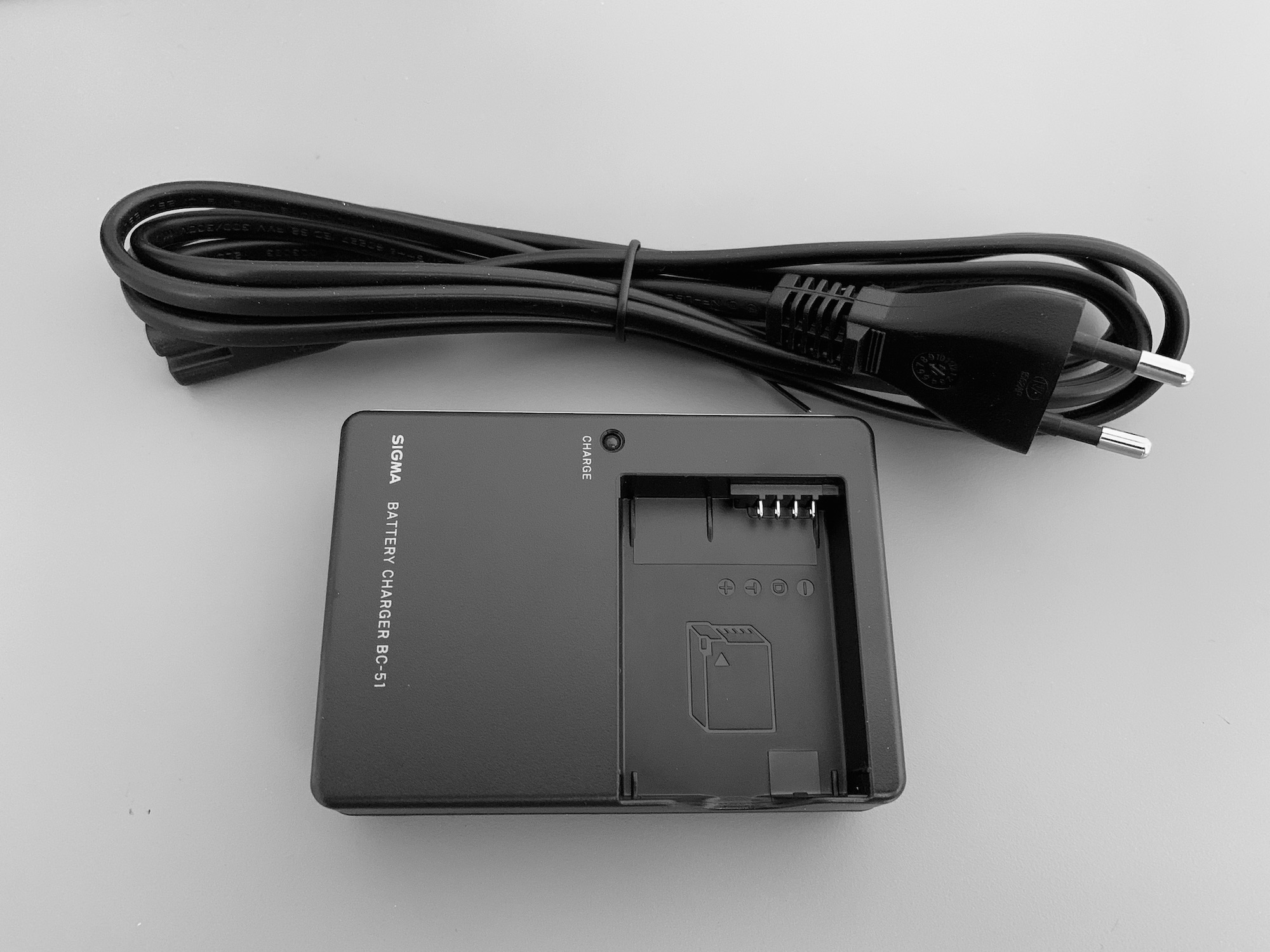 SIGMA BC-51 battery charger and its power cord with euro plug.